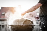 Rauchender Holzkohlegrill auf dem Balkon