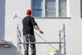 Mann streicht Fassade